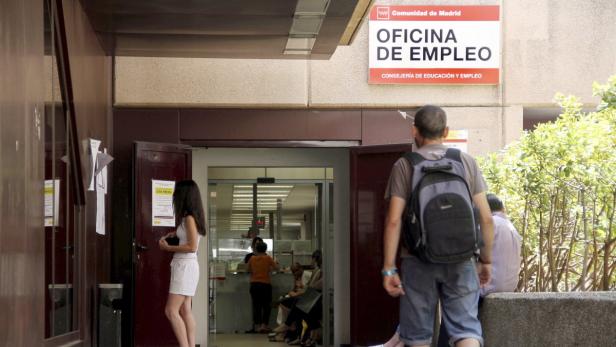 Menschen betreten oder verlassen ein Büro der Arbeitsagentur in Madrid.