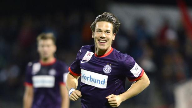 Ein lächelnder Fußballspieler im lila Trikot von Austria Wien.