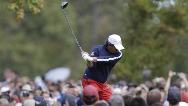 Ein Golfspieler schwingt seinen Schläger vor einer Zuschauermenge.