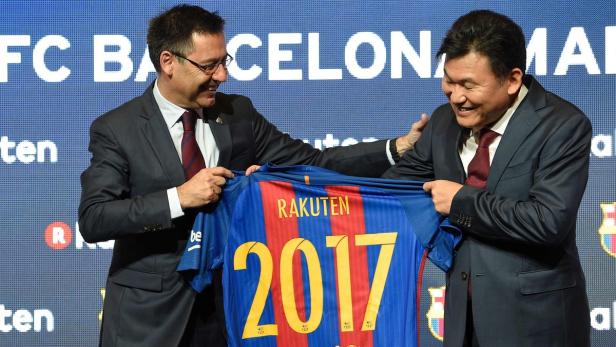 Zwei Männer präsentieren ein FC Barcelona-Trikot mit der Aufschrift „Rakuten“ und der Nummer 2017.