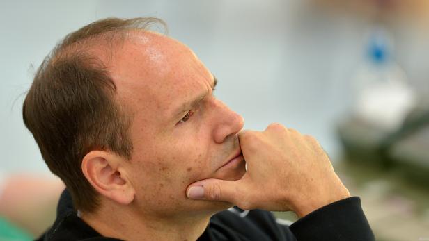 Ein Mann mit ernstem Gesichtsausdruck stützt sein Kinn auf seine Hand.