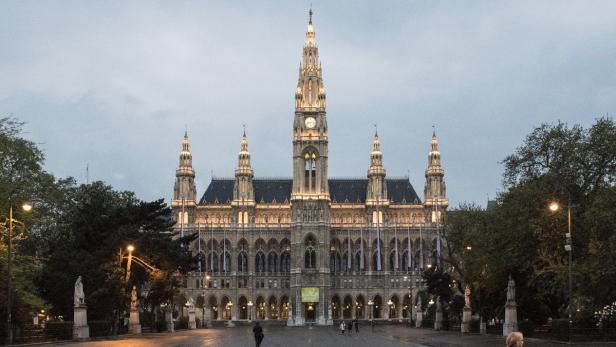 Das Wiener Rathaus mit beleuchteter Fassade in der Abenddämmerung.