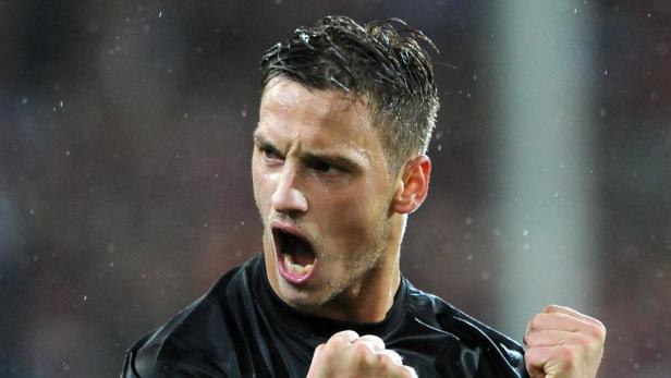 Ein Mann jubelt mit geballten Fäusten und geöffnetem Mund.