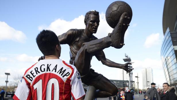 Ein Mann in einem Bergkamp-Trikot vor der Statue von Dennis Bergkamp.