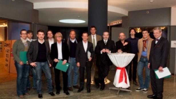 Eine Gruppe von Personen posiert in einer Halle für ein Foto.