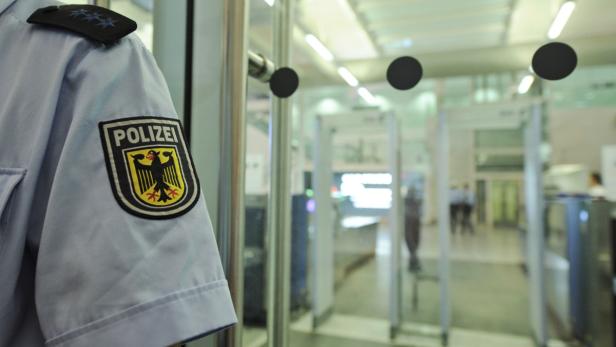 Die Uniform eines deutschen Polizisten vor einer Sicherheitsschleuse.