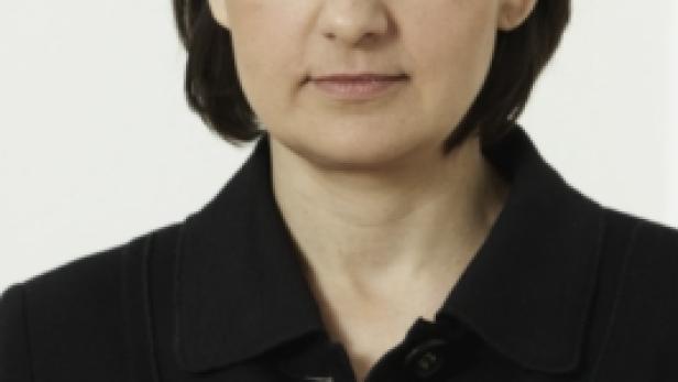Porträt einer Frau mit dunklen Haaren und einem schwarzen Blazer.