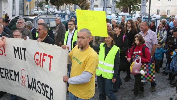 Demonstranten protestieren gegen die Wasserverschmutzung mit Schildern und Transparenten.