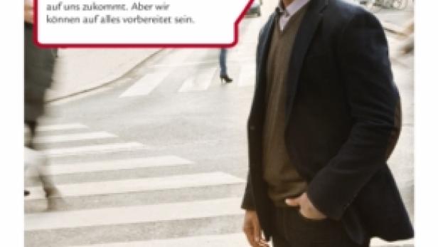 Ein Mann in einem Anzug steht auf einem Zebrastreifen in einer Stadt.