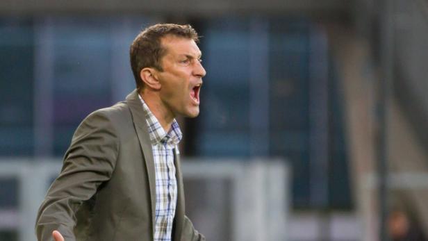 Ein Mann in einem Anzug schreit mit geöffnetem Mund.