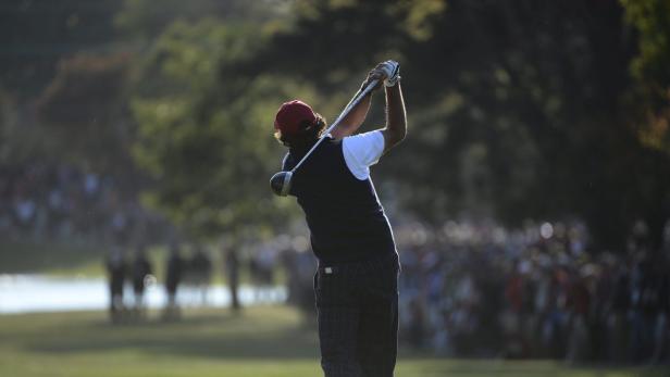 Ein Golfer schwingt seinen Schläger vor einer Zuschauermenge.