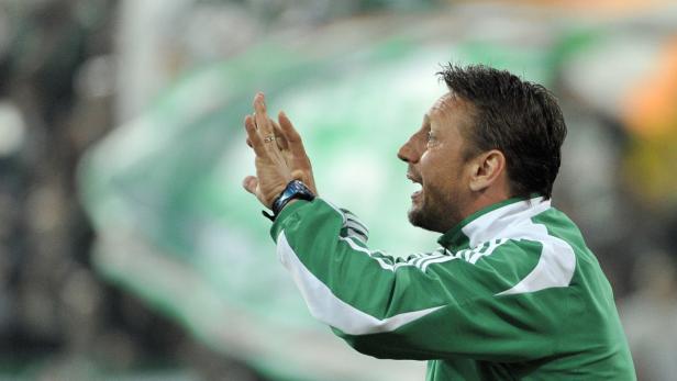 Ein Trainer gestikuliert während eines Fußballspiels.
