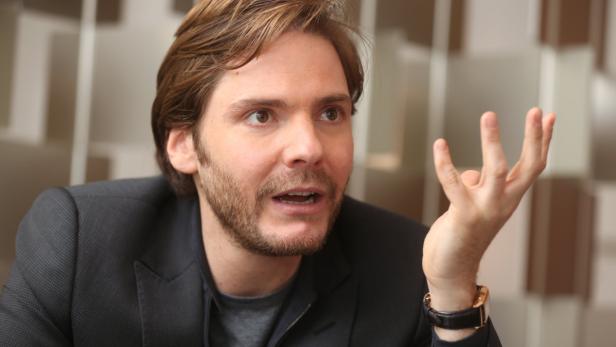 Daniel Brühl gestikuliert während eines Interviews.