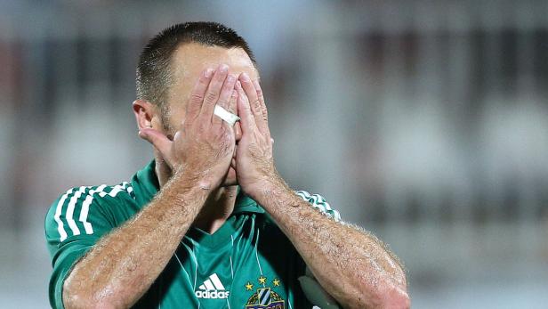 Ein Fußballspieler mit einem Pflaster am Finger verdeckt sein Gesicht mit den Händen.