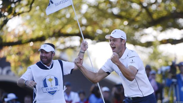 Ein Golfer und sein Caddie jubeln mit geballten Fäusten über einen Sieg.