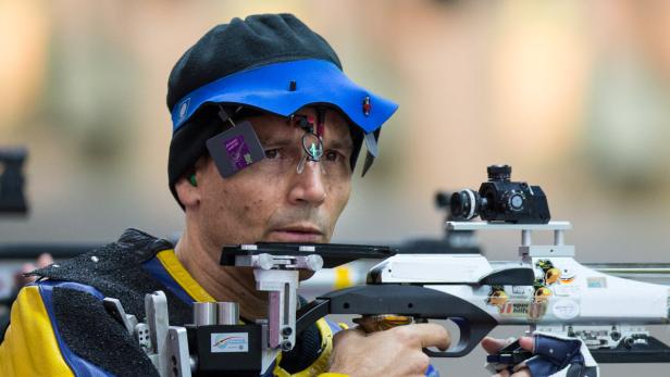 Ein Schütze zielt mit einem Luftgewehr auf eine Zielscheibe.