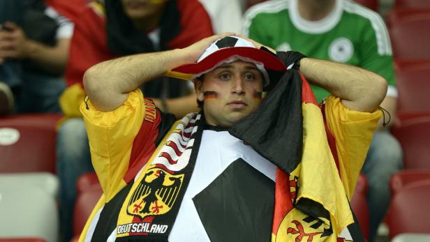 Ein enttäuschter deutscher Fußballfan mit Deutschlandfarben im Gesicht und einem Deutschlandhut auf dem Kopf.