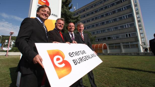 Vier Männer in Anzügen präsentieren ein Schild von „Energie Burgenland“.