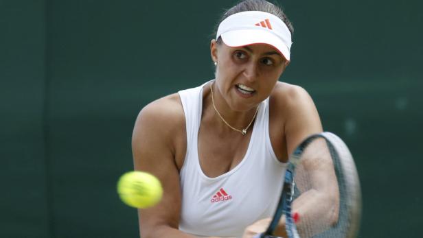 Eine Tennisspielerin schlägt einen Ball mit ihrem Schläger.