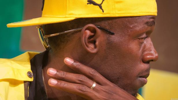Nahaufnahme von Usain Bolt mit gelber Kappe und gelber Jacke.