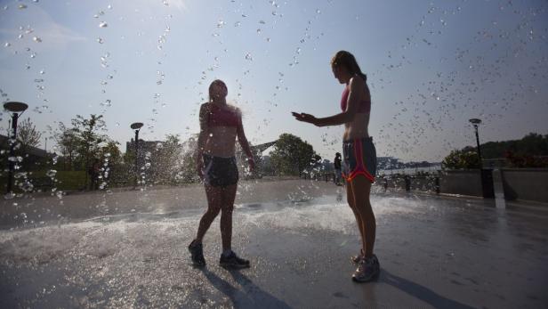 EPAepa03299395 Claire Leatherwood (L) and Lindsay Donaldson (R) cool off in a Georgetown fountain as temperatures surpass the 95 degree Fahrenheit (35 degrees Celcius) mark for the tenth straight day in Washington DC, USA, 07 July 2012. The massive heat w Hitzewelle beutelt die USA