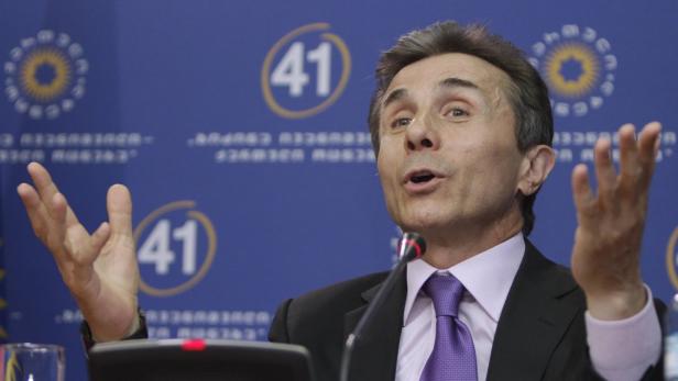 Ein Mann in Anzug gestikuliert vor einem blauen Hintergrund mit der Zahl 41.