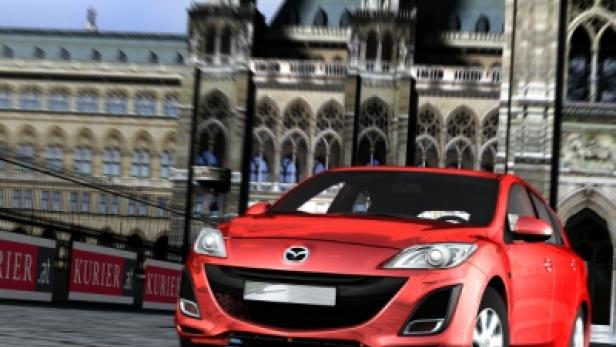 Ein roter Mazda fährt vor einem historischen Gebäude in Wien.
