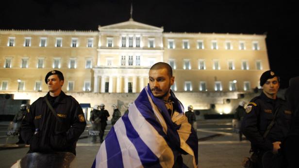 Ein Mann mit griechischer Flagge vor dem griechischen Parlament in Athen.