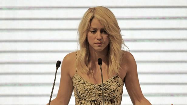 Shakira steht vor Mikrofonen und spricht.