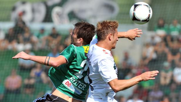 Zwei Fußballspieler kämpfen um einen Ball in der Luft.