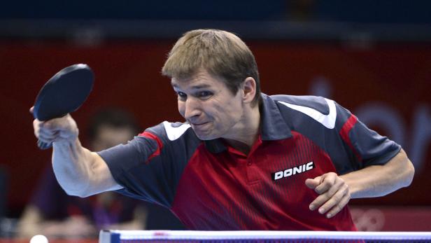 Ein Tischtennisspieler schlägt den Ball mit seinem Schläger.