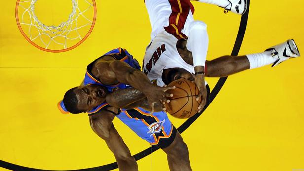 Zwei Basketballspieler kämpfen um den Ball unter dem Korb.