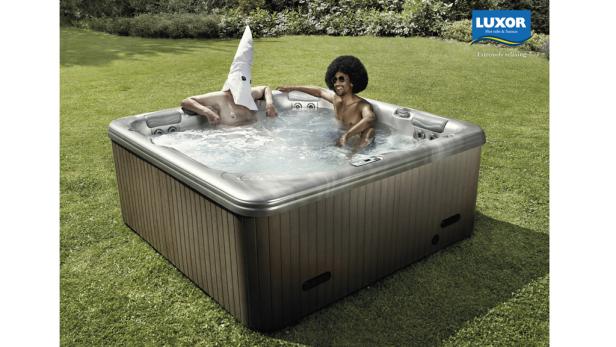 Zwei Männer entspannen in einem Whirlpool im Garten.