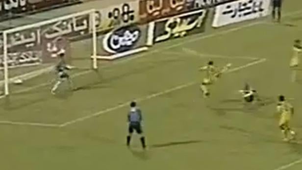 Ein Fußballspieler schießt den Ball in Richtung Tor.