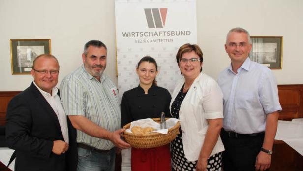 Eine Gruppe von Personen posiert vor einem Banner des Wirtschaftsbundes Bezirk Amstetten.