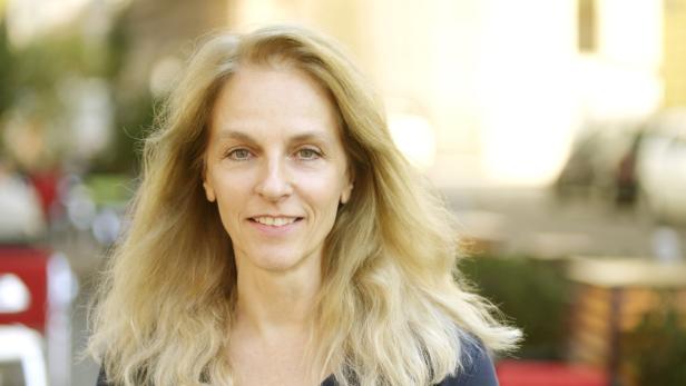 Porträt einer Frau mit langen, blonden Haaren und einem freundlichen Lächeln.