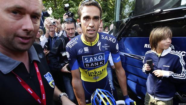 Ein Radrennfahrer im Trikot von Saxo Bank, umringt von Fans und Fotografen.