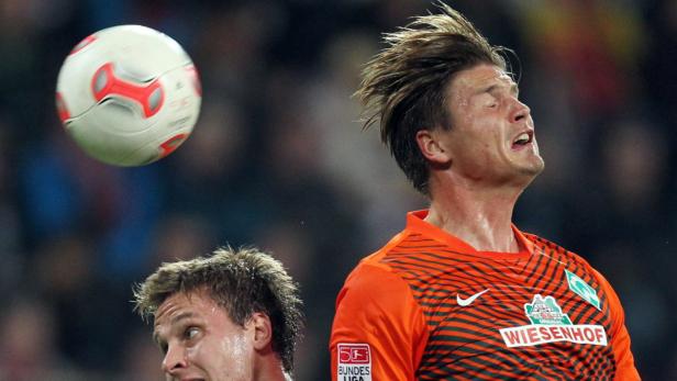 Ein Fußballspieler köpft einen Ball während eines Spiels.