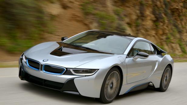 Ein silberner BMW i8 fährt auf einer Straße.