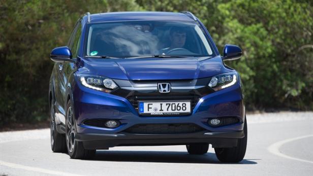Ein blauer Honda HR-V fährt auf einer kurvigen Straße.