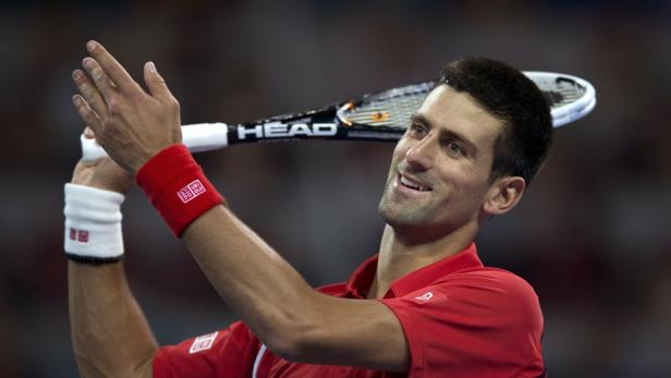 Novak Đoković mit Tennisschläger lächelt.