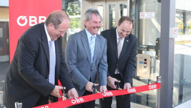 Drei Männer im Anzug durchschneiden ein rotes Band der ÖBB.