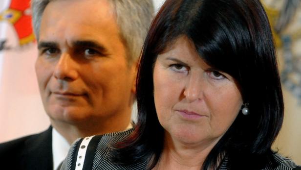 Eine Frau mit dunklen Haaren und ein Mann mit grauen Haaren stehen nebeneinander.