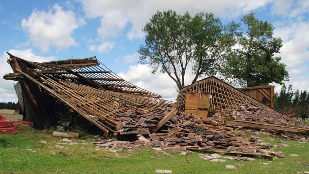 Ein zerstörtes Gebäude liegt auf einer grünen Wiese.