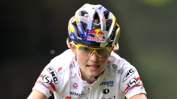 Eine Mountainbikerin mit Helm und gelber Brille während eines Rennens.