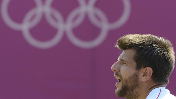 Ein Mann im Profil vor dem Hintergrund der Olympischen Ringe.