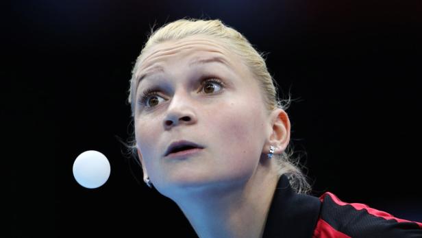 Eine Tischtennisspielerin blickt aufmerksam auf den Ball.