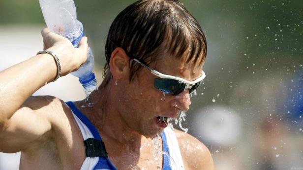 Ein erschöpfter Sportler schüttet sich Wasser über den Kopf.