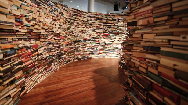 Ein Gang, dessen Wände vollständig aus Büchern bestehen.