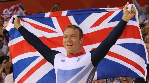 Ein Radrennfahrer feiert mit der britischen Flagge seinen Sieg.